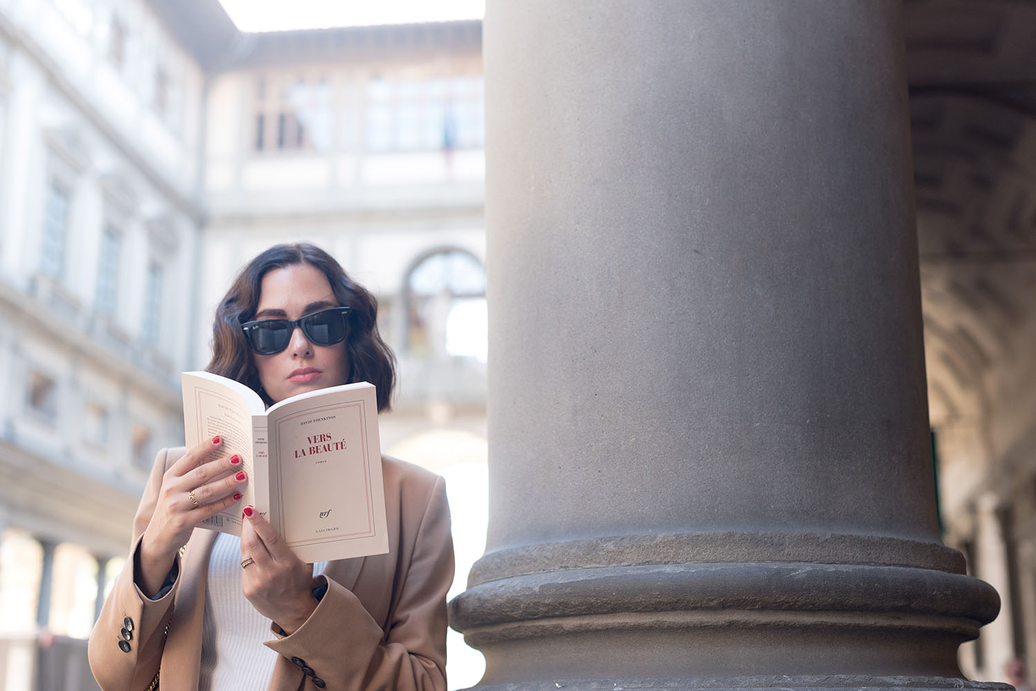 Portrait of top Winnipeg fashion blogger Cee Fardoe of Coco & Vera, reading Vers la beaute by David Foenkinos in Florence, Italy while wearing RayBan Wayfarer sunglasses