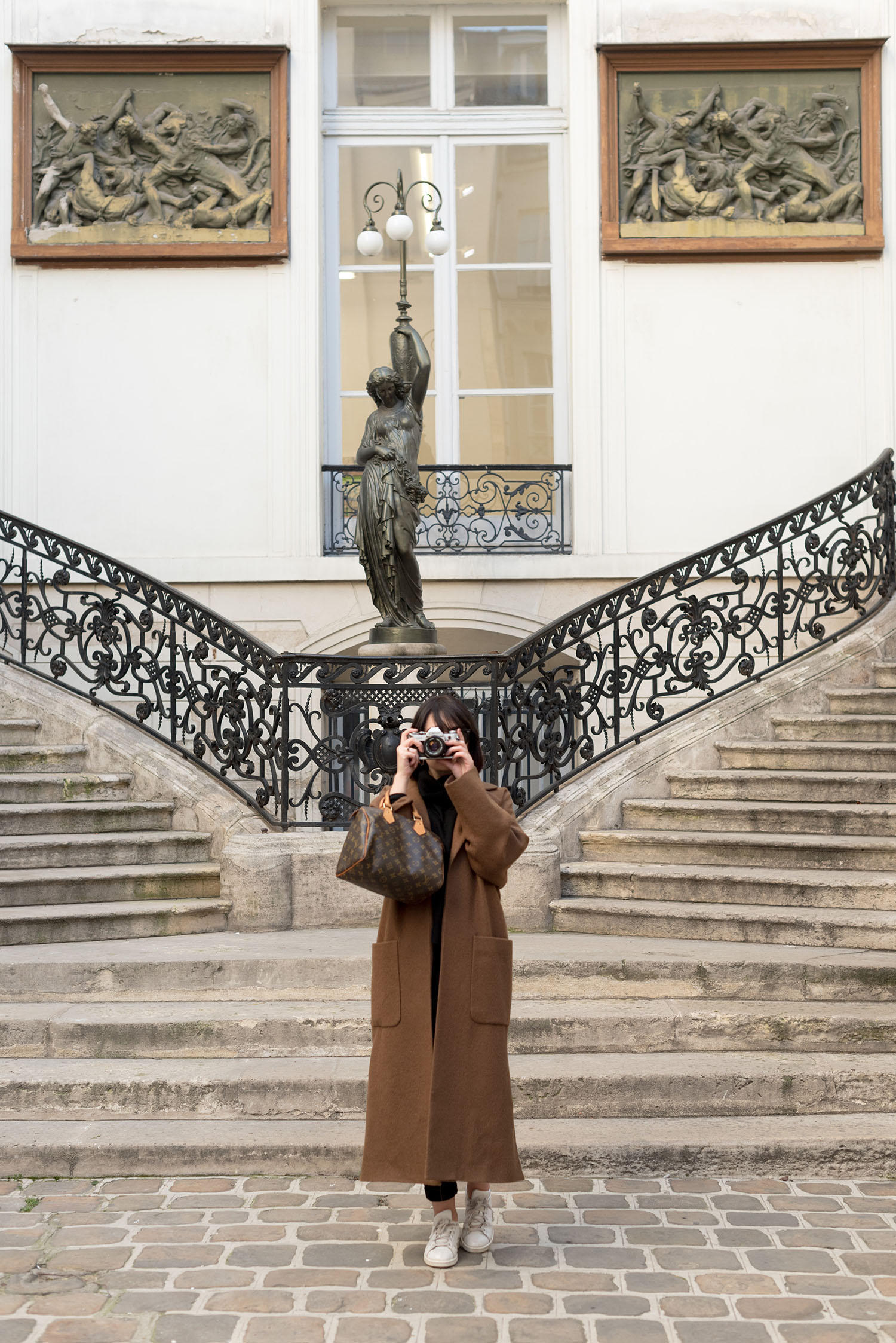 Top Winnipeg fashion blogger takes a picture at Galerie Perrotin in Paris, wearing a Zara wrap coat and carrying a Louis Vuitton Speedy 25 handbag