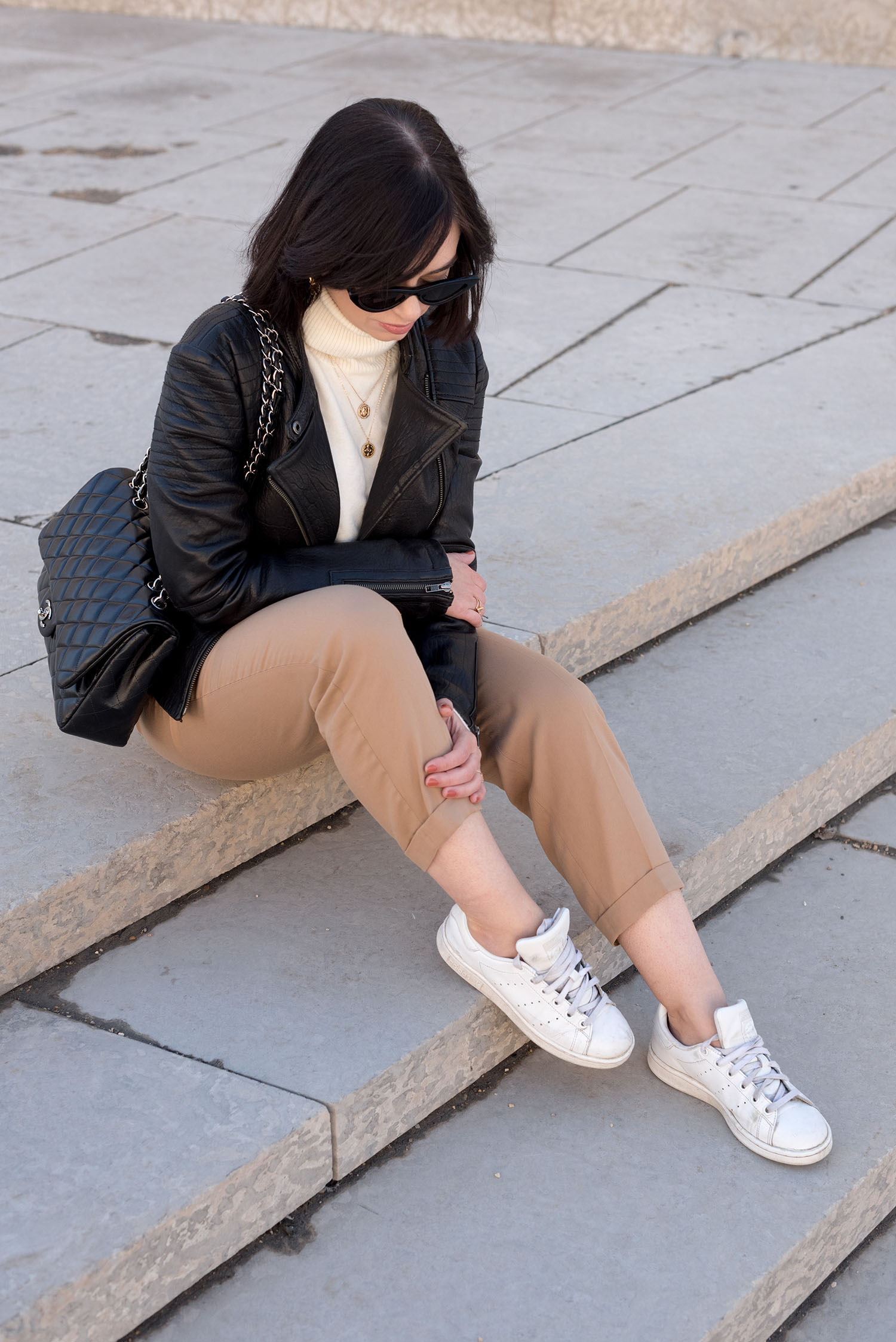 Top Canadian fashion blogger Cee Fardoe of Coco & Vera sits outside the Winnipeg Art Gallery wearing Zara beige trousers and a Cupcakes and Cashmere leather jacket, thinking about why she continues to blog